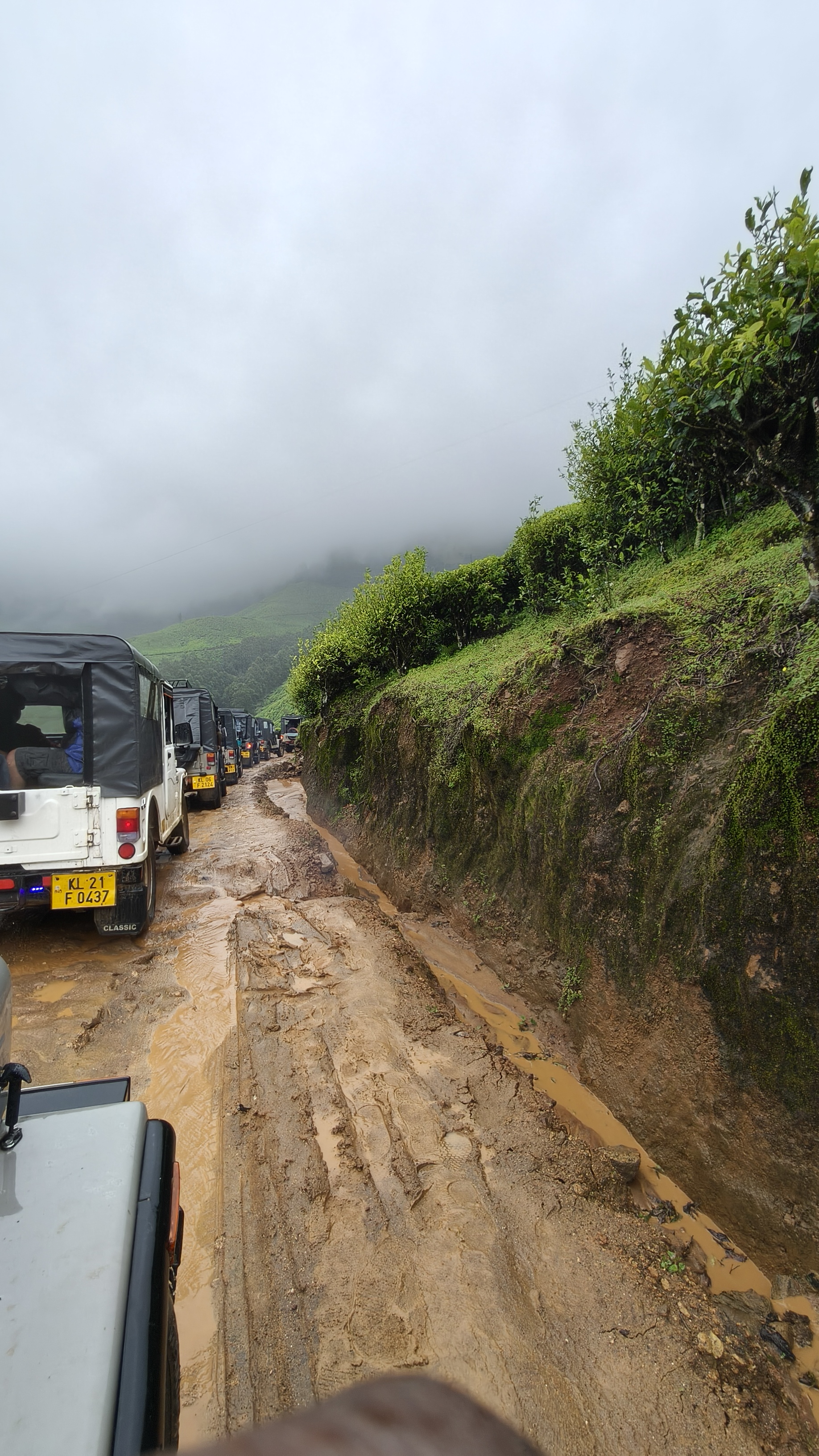Kolukkumalai jeep safari on muddy off-road trail with mist-covered tea estates
